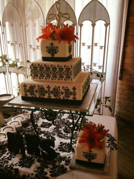 An elegant black and white wedding cake with lilies.