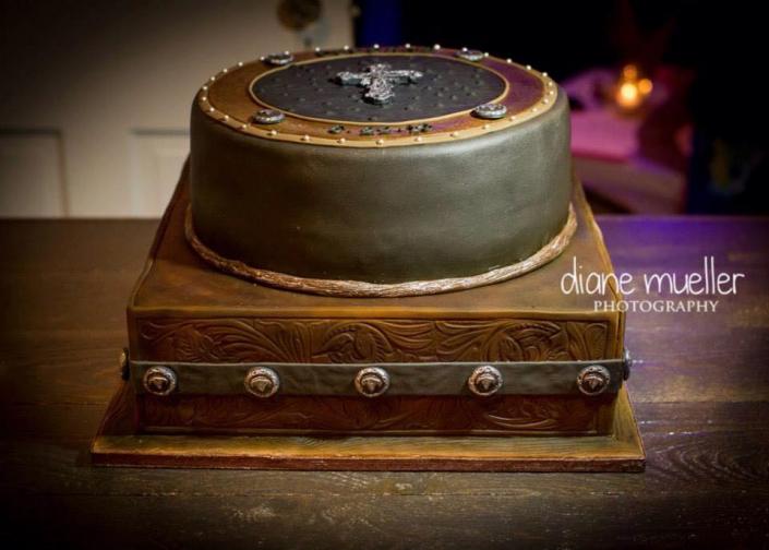 This is a beautiful golden brown cake etched with cowboy-inspired decorations. 