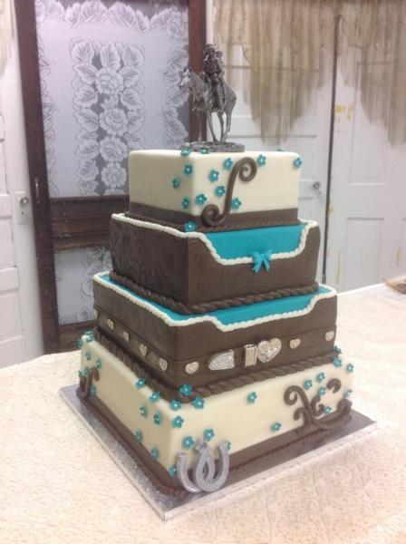 A unique cowboy themed wedding cake with a belt buckle and horseshoes.