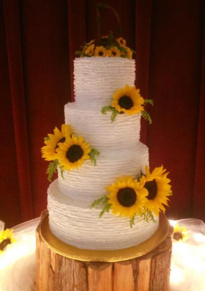 A beautiful 4 tier wedding cake with sunflowers.