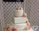 A 4 tier wedding cake with various shapes as well as crystal embellishment.