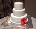 A beautiful wedding cake with an orange rose.