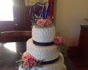 A beautiful 3 tiered wedding cake with beautiful designs and fresh flowers.